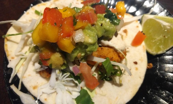 Blackened swordfish taco with cabbage, mango, avocado, papaya and cumin crema